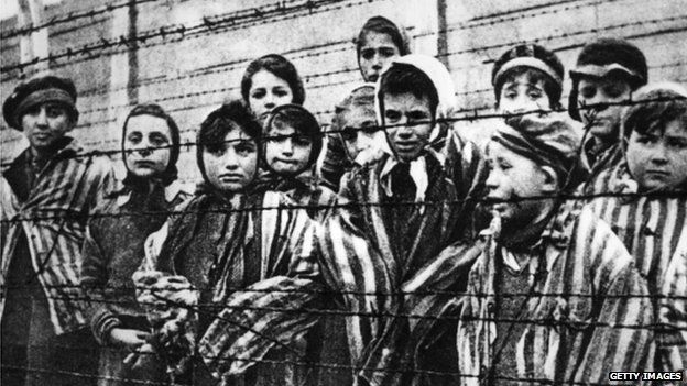 Children behind a barbed wire fence at the Nazi concentration camp at Auschwitz in southern Poland