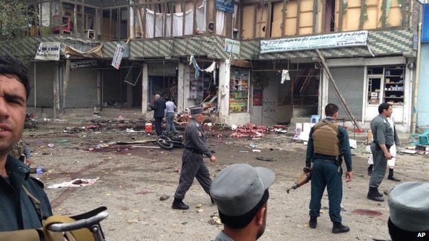 Afghan security forces inspect the site of a suicide attack near a bank branch in Jalalabad, east of Kabul, Afghanistan, Saturday, April 18, 2015.