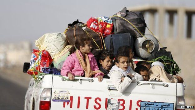 File photo: Children ride on the back of a pick-up truck with their luggage as they flee Saudi-led air strikes in Sanaa, 6 April 2015