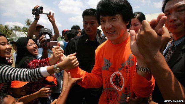 Hollywood action star Jackie Chan greets local people during an emotional visit to Indonesia's devastated Banda Aceh in Indonesia, 18 April 2005