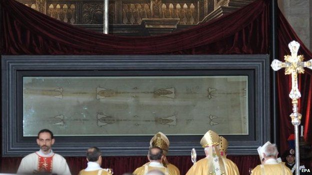People attend a mass with the Turin Shroud being exhibited inside Turin's cathedral. Photo: 19 April 2015