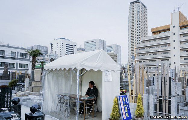 A man waits for customers at the Aoyama cemetery