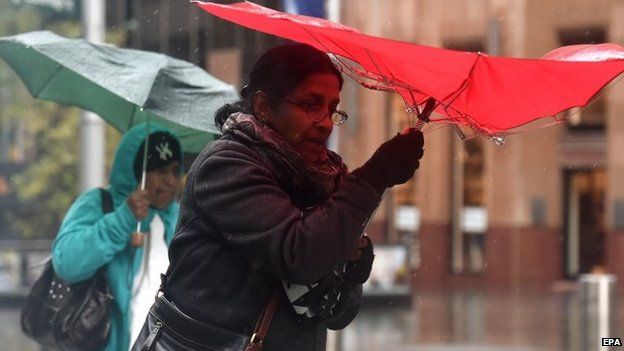Pedestrians shelter under umbrellas from heavy rain in Sydney, NSW, Australia, 20 April 2015