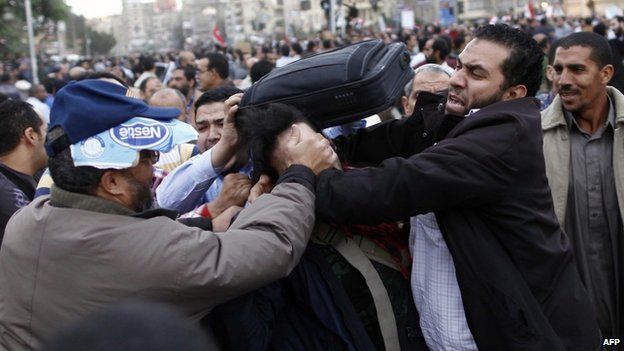 Members of the Muslim Brotherhood and supporters of Egyptian President Mohammed Morsi scuffle with an anti-Morsi protester during clashes outside the presidential palace on December 5, 2012 in Cairo