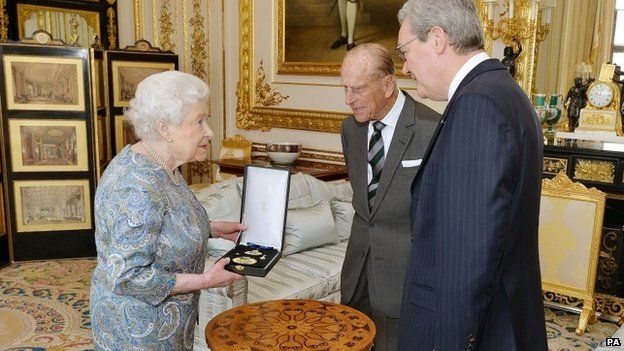Queen Elizabeth II talks with the Australian High Commissioner, Alexander Downer (right) as she prepares to present the Duke of Edinburgh, with the Insignia of a Knight of the Order of Australia
