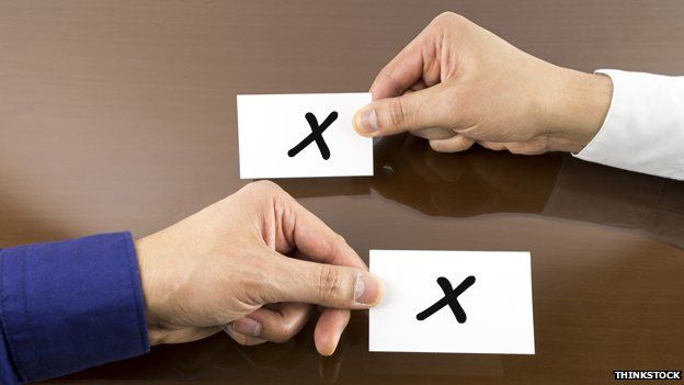 Two hands swapping papers marked "X"