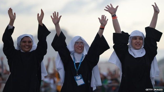 Three nuns waving their arms in the air