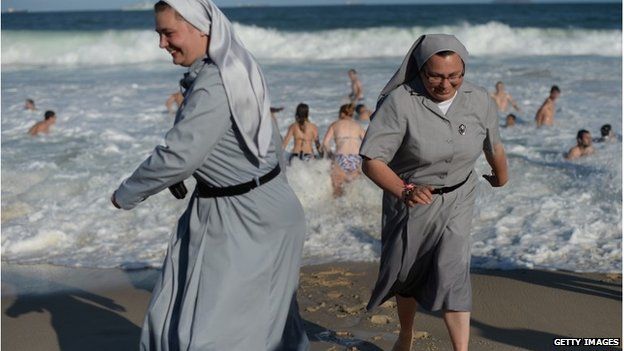 Two Polish nuns running on the beach