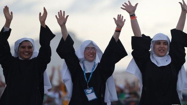 Three nuns waving their arms in the air