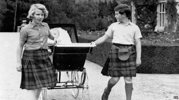 Prince Charles and Princess Anne pull a pram containing their baby brother Prince Andrew