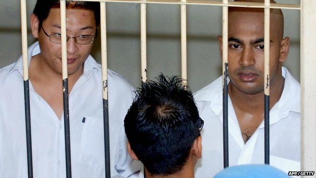 Australian drug traffickers Andrew Chan (L) and Myuran Sukumaran (R) the ringleaders of the "Bali Nine" drug ring, look on from a holding cell while awaiting a court trial in Denpasar on Bali island in 2006