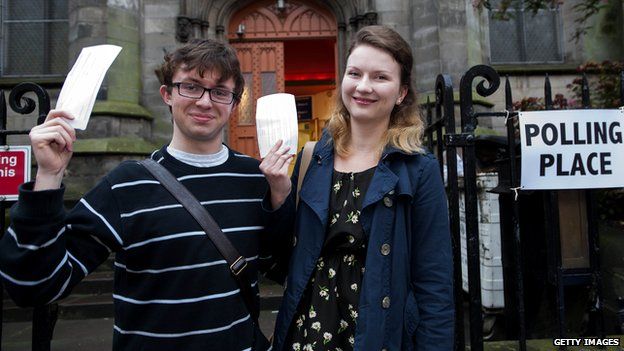 Couple hold up voting slips outside Edinburgh polling station