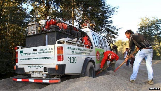 Volunteers dig out a fire truck belonging to Chile"s National Forest Corporation (CONAF), which got stuck in the ash from the Calbuco volcano, in Petrohue April 23, 2015