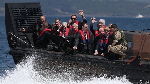 Relatives of veterans of the Gallipoli Campaign wave from an amphibious landing craft