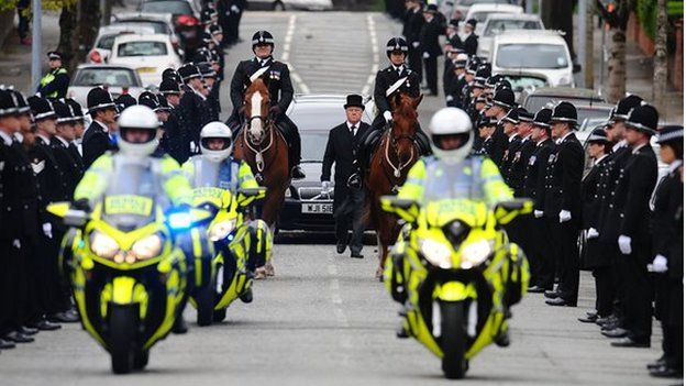 Police motorcycles and horses led the hearse to the church