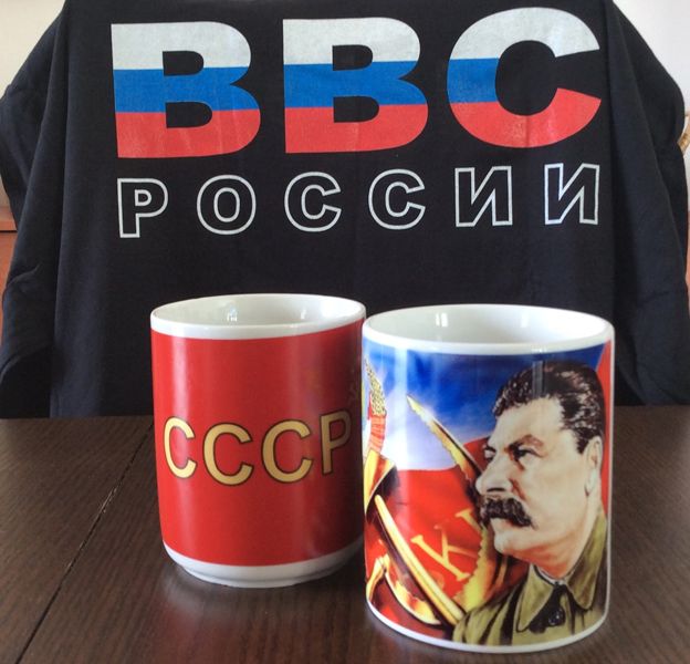 A T-shirt and two mugs, one with a picture of Stalin and the other with the Cyrillic letters for USSR