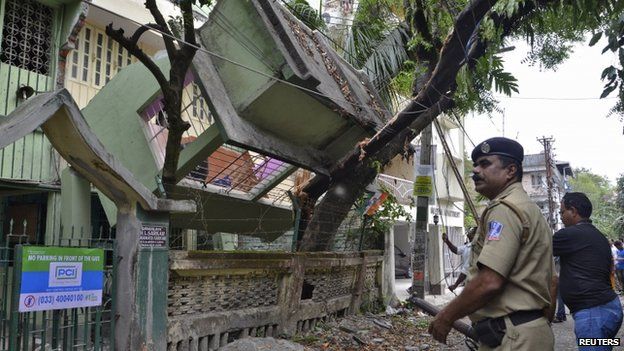 An Indian security personnel stands near a collapsed house after an earthquake in Siliguri, India