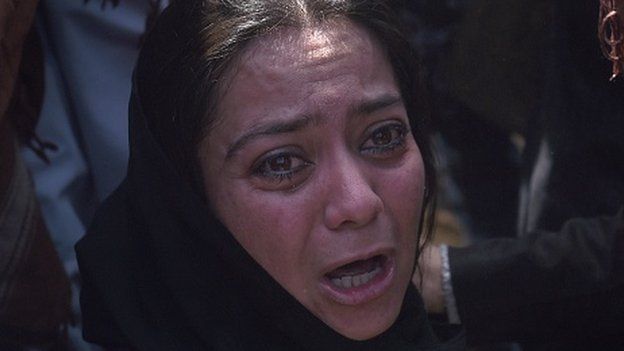 An independent Afghan civil society activist woman weeps at the grave-side of Afghan woman Farkhunda, 27, who was lynched by an angry mob, during her funeral in central Kabul on March 22, 2015.