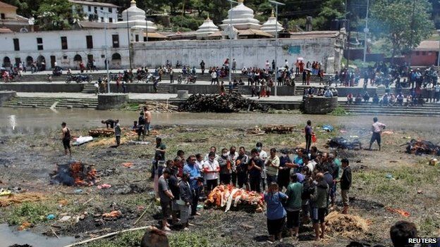 People pray before cremating a body in Kathmandu, Nepal, after the massive earthquake, 27 April 2015
