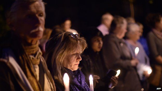 Participants observe a minute's silence for the Nepal earthquake victims during a candle light vigil on Sydney Harbour foreshore on April 27, 2015