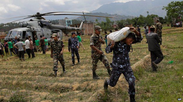 Nepalese soldiers unloading relief supplies from an Indian air force helicopter