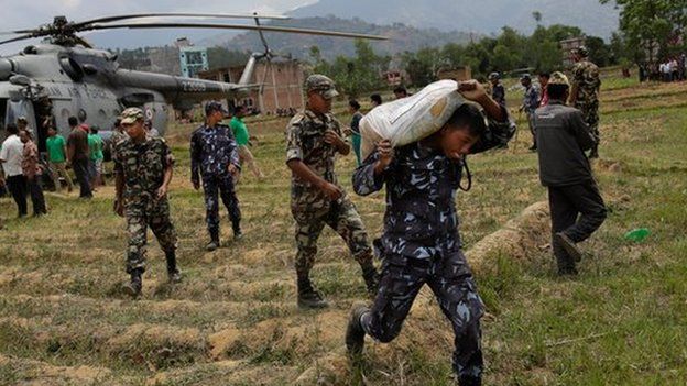 Nepalese soldiers unloading relief supplies from an Indian air force helicopter