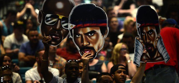Fans hold up images of Mayweather and Pacquiao