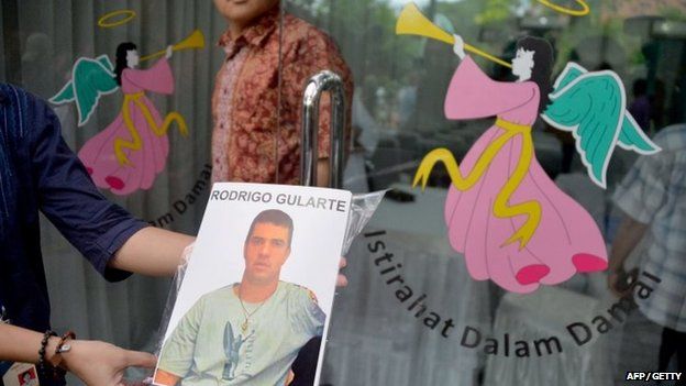A woman displays a photograph of executed Brazilian drug convict Rodrigo Gularte at the hospital morgue in Jakarta on April 29, 2015.