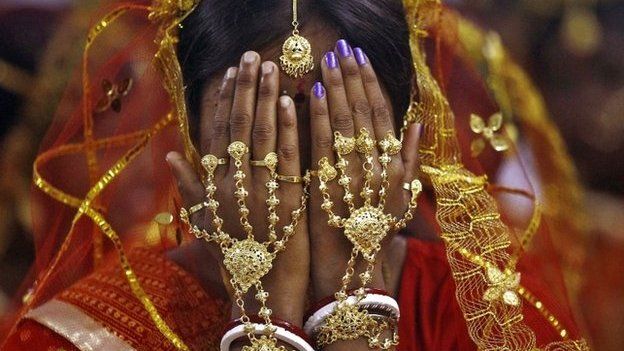 A bride covers her face as she waits to take her wedding vow at a mass marriage ceremony at Bahirkhand village, north of Kolkata February 8, 2015.