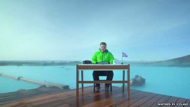 Gudmundur of the North sitting at a desk in front of a wide expanse of water