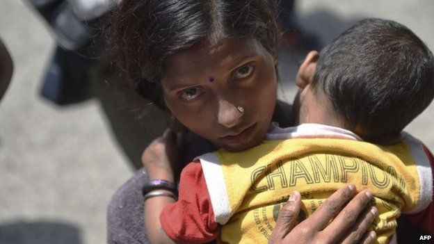 A Nepalese woman holds her sick child in her arms as she waits to be seen by medics of the Joint Disaster Relief Medical support unit of the Japanese Defence Forces at a camp in Kathmandu on May 1, 2015,
