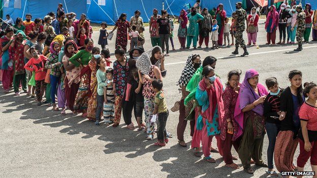 Victims of the earthquake queue to receive food and goods at a relief camp in Kathmandu