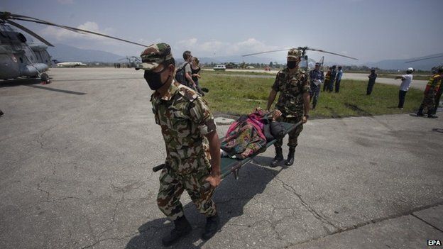 Nepali soldiers carry an injured woman rescued form Sindhupalchock district of Nepal, at Kathmandu International Airport