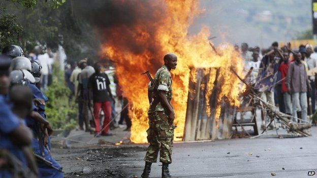A soldier stands between demonstrators and riot police facing off in the Musaga district of Bujumbura, Burundi, 4 May 2015