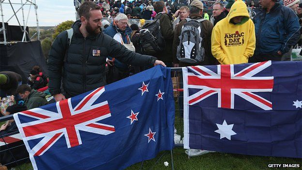 Visitors pack up New Zealand (L) and Australian flags at the conclusion of the Dawn Service at the Anzac Commemorative Site, which is the main event to commemorate Australian soldiers who died during the Gallipoli campaign, on the campaign's centenary on 25 April 2015 near Eceabat, Turkey.