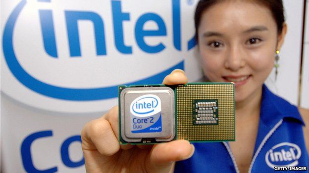 Intel worker holding two of the firm's microchips