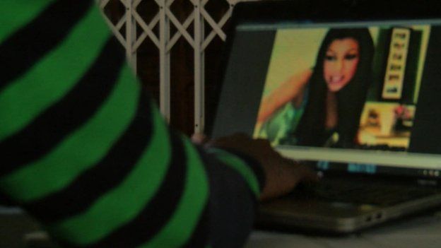 Man on computer showing a woman on screen