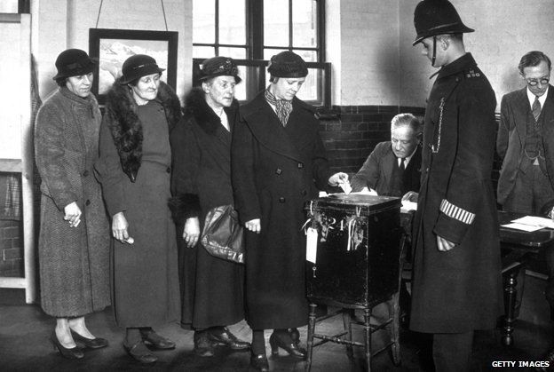 Black and white photo of four ladies waiting to vote