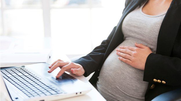 Pregnant woman at keyboard