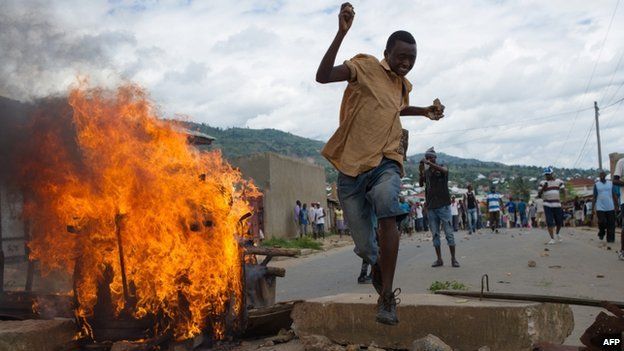 A Burundian protester jumps over a barricade in the Mugasa neighbourhood of Bujumbura on 6 May 2015