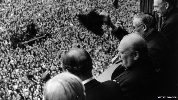 British Prime Minister Winston Churchill (1874 - 1965) waving to crowds gathered in Whitehall on VE Day, 8th May 1945.