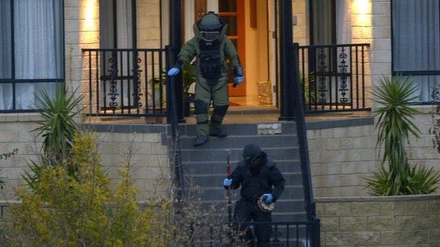 Officers wearing bomb suits raid a home in Greenvale, Melbourne, Australia, 8 May 2015