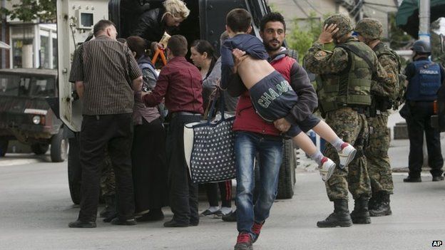 People are evacuated safely from the scene of an altercation involving the police, in northern Macedonian town of Kumanovo, on Saturday, 9 May 2015.