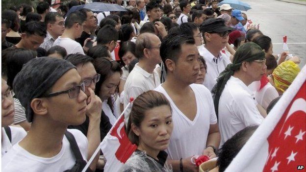 Singaporeans wait for the coffin of Lee Kuan Yew to pass during the funeral procession, Sunday, 29 March 2015, at the Padang parade grounds and City Hall in Singapore.