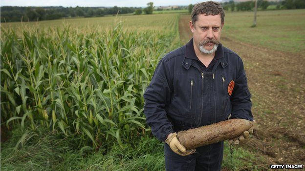Mine-clearing specialist Raoul Weber holds an unexploded German 105mm artillery shell from World War I found by a local farmer in a corn field at Champneuville on August 26, 2014