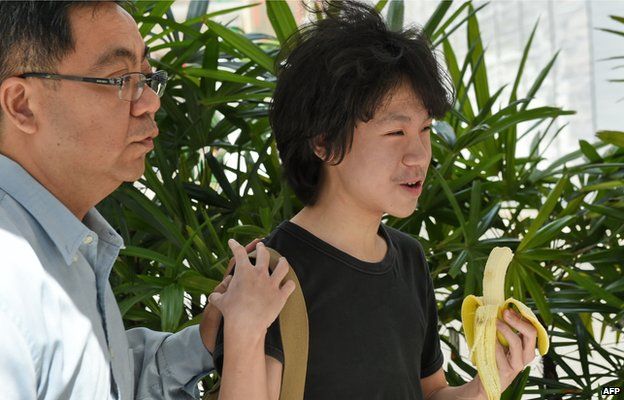 16-year-old student Amos Yee walks with his father to the State courts in Singapore on 17 April 2015.