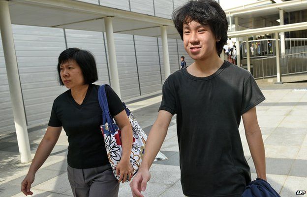 Amos Yee (R), a 16-year-old student, and his mother leave the State courts in Singapore on 31 March 2015.