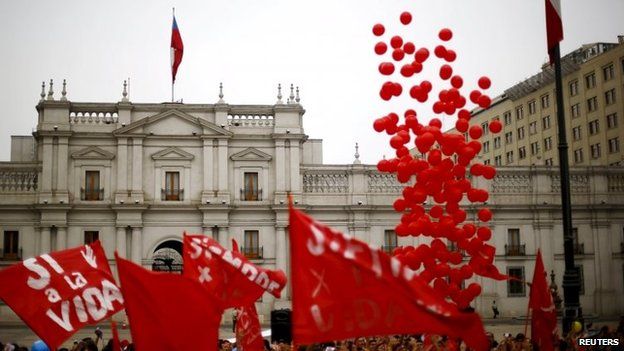 Demonstrators wave flags as they gather during a rally against the draft law of the Chilean government which seeks to legalize abortion in Santiago on 23 March, 2015.