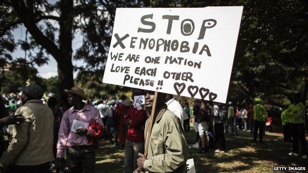 A demonstrator holds a banner through in Johannesburg on April 23, 2015 during a march gathering several thousands of people to protest against the recent wave of xenophobic attacks in South Africa