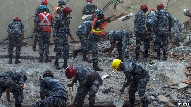 Rescuers work amid the latest quake damage in Kathmandu, 12 May